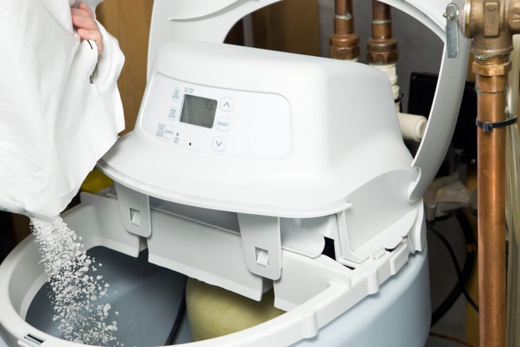Water softener system with sodium beads being poured in